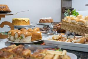 a table filled with different types of pastries and cakes at Hotel Conexão in Penha