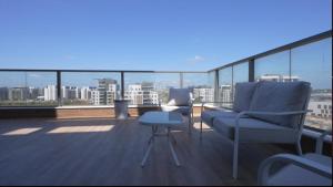 Luxury Penthouse 5 Rooms في Or Yehuda: شرفة مع أريكة وطاولة على السطح