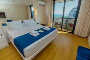 a bedroom with a large bed with towels on it at Batumi City Apartments in Batumi