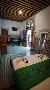 a bedroom with a bed and a stained glass window at Riad Green House in Fès