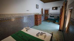 a room with a bed and a tv in a room at Riad Green House in Fès