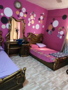 - une chambre avec 2 lits et des murs violets dans l'établissement سرايات المعادي القاهرة, au Caire