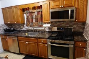 a kitchen with a stove and a sink and a microwave at Handsome Home - 4 minutes close to Metro in Lanham