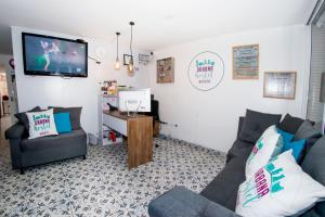 a living room with a couch and a tv on the wall at Urbana Hostel in Bogotá