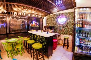 bar z zielonymi stołkami i blatem z napojami w obiekcie Urbana Hostel w mieście Bogota