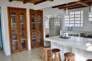 cocina con encimera y taburetes de madera en Casa Manglar, en Tolú