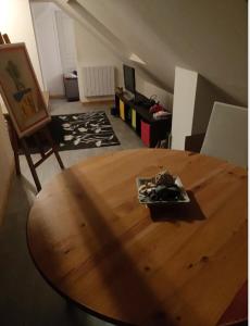 einen Holztisch im Wohnzimmer mit Esstisch in der Unterkunft Chambre en campagne proche de la mer 1 in Tréméreuc