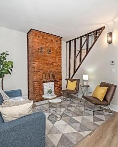 a living room with a couch and chairs and a brick wall at Hip and Bright Lawerenceville 2 Bed Easy Parking in Pittsburgh