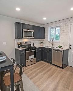 a kitchen with black cabinets and stainless steel appliances at Hip and Bright Lawerenceville 2 Bed Easy Parking in Pittsburgh