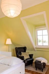 ein Schlafzimmer mit einem schwarzen Stuhl und einem Fenster in der Unterkunft Charmante, großzügige Ferienwohnung Villa Fleurie in Bretten