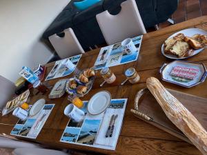 a wooden table with breakfast foods on it at Chez Tib in Trégunc