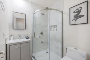 y baño con ducha, aseo y lavamanos. en @ Marbella Lane - Cozy & Bright Duplex in W Covina, en West Covina