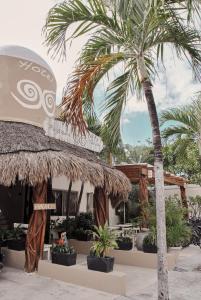 palma przed budynkiem pełnym roślin w obiekcie Boutique Hotel Posada 06 Tulum w mieście Tulum