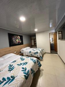 a bedroom with two beds and a tv on the wall at DOÑA EMMA in Sibundoy