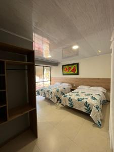 ein Schlafzimmer mit 2 Betten und einem TV. in der Unterkunft DOÑA EMMA in Sibundoy