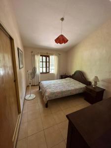 Un dormitorio con una cama y una lámpara. en Él Algarrobo en San Antonio de Arredondo