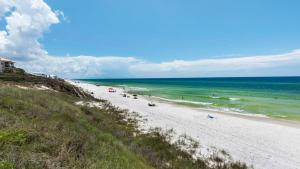 ein Strand mit Menschen im Sand und im Meer in der Unterkunft Lazy Days in Seacrest