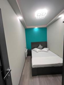 a bedroom with a bed and a blue wall at ROMANTIC ATMOSPHERE Self Check In in Yerevan