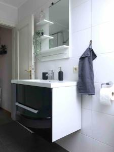a white bathroom with a sink and a mirror at Ferienwohnung Friesenstube in Zetel