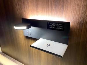 ein Licht an einer Holzwand mit einem Laptop darauf in der Unterkunft hotel mio omiya - Vacation STAY 64001v in Saitama