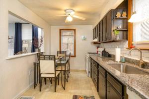 a kitchen with a sink and a table with chairs at Stylish and Refined with Easy City Access in Pittsburgh