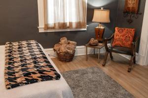 a bedroom with a bed and a chair and a lamp at Stylish and Refined with Easy City Access in Pittsburgh