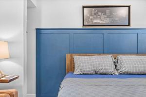 cabecero azul de una cama con 2 almohadas en Trendy & Hip South Side Studio Walk to Downtown, en Pittsburgh