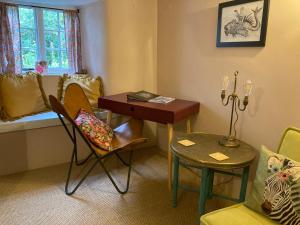 ein Zimmer mit einem Schreibtisch und Stühlen und einem Bett in der Unterkunft 4 Cumberland Cottages in Kingsbridge + 31 Fotos