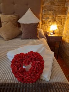 ein großer Strauß roter Rosen auf dem Bett in der Unterkunft Picasso Carreteria History Center in Málaga