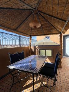 uma mesa com cadeiras e um guarda-sol num pátio em Hotel Apartments Lexpert em Merzouga