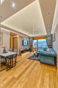 a living room with a blue couch and a table at Apartman Lux M&B 2 in Zlatibor