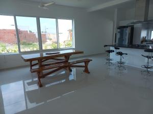 cocina con mesa de madera en una habitación con ventanas en Casa Quinta piscina privada y jacuzzi en cercanías a Girardot, en Girardot