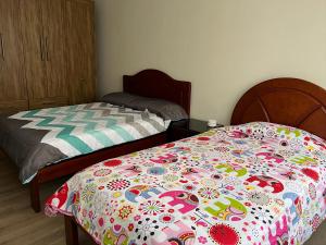 a bedroom with a bed with a flowered blanket at Departamento Sector de la Embajada Americana in Quito