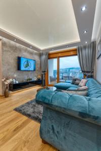 a living room with a blue couch and a tv at Apartman Lux M&B 2 in Zlatibor