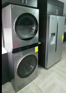 duas máquinas de lavar roupa sentadas uma ao lado da outra num quarto em Departamento Sector de la Embajada Americana em Quito