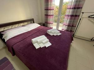 a bed with two slices of soap on a purple blanket at Νέο διαμέρισμα πολυκατοικίας σε ιστορικό κέντρο in Thessaloniki