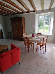 a living room with a table and chairs at Charmant gîte : Les flambeaux in Mareuil-en-Brie