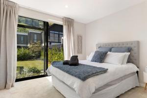 a bedroom with a bed and a large window at Little Alp Chalet in Queenstown