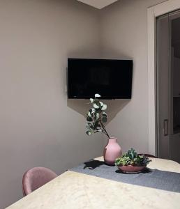 una habitación con una mesa con un jarrón con una planta en Il Cortile en Enna