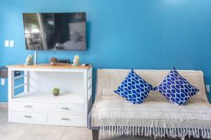 a room with a white dresser and a couch with blue walls at Cozy Beach Getaway - Lux Studio next to The Morgan Village in Maho Reef