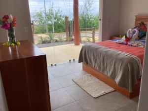 a bedroom with a bed and a large window at Casa Bajito Bay in Troncones