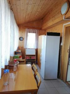 eine Küche mit einem Tisch und einem weißen Kühlschrank in der Unterkunft Chata Kubíček na Šumavě in Prachatice