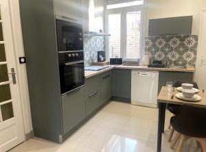 a kitchen with a green refrigerator and a table at #GREENHOME# in Dunkerque