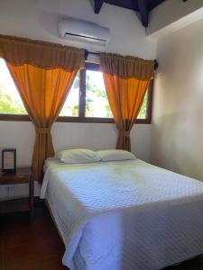 a bedroom with a bed and two windows at HOTEL UTZTZABA in Monterrico