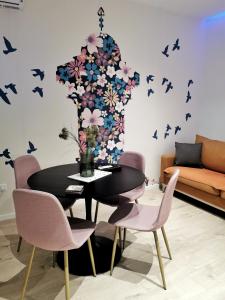 comedor con mesa negra y sillas rosas en Blue and Rose Cozy - Quiet in the Best Location - Self Check-in - 5th Floor with Elevator, en Sarajevo