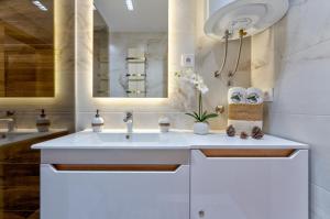 a bathroom with a white sink and a mirror at Apartman Lux M&B 2 in Zlatibor +48 photos