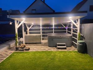 a pergola with a mattress on a patio at night at Nemes Apartmanház Tóalmás in Tóalmás