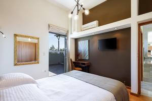 a bedroom with a bed and a tv on a wall at Rizes Villa with Jazuzzi & Heated Pool in Agia Triada