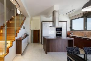 a kitchen with a staircase and a kitchen with a counter at Rizes Villa with Jazuzzi & Heated Pool in Agia Triada