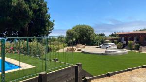 een achtertuin met een hek en een zwembad en een tuin bij Cabañas Puertecillo in Puertecillo